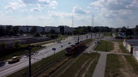 a tram driving in the city, a street with cars on the background