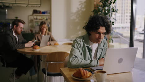 a man working on a laptop at a cafe
