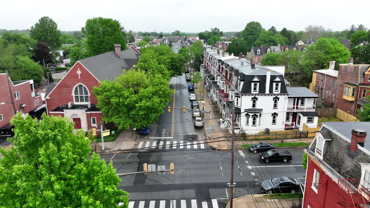 Flyover of city street. Rainy, wet day in spring. Houses and church in downtown.
