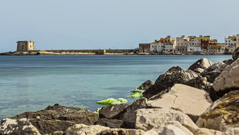 Toma-De-Timelapse-De-Las-Ruinas-De-Un-Edificio-Histórico-A-Lo-Largo-De-La-Orilla-Del-Mar-En-Trapani,-Sicilia,-Italia-En-Un-Día-Soleado