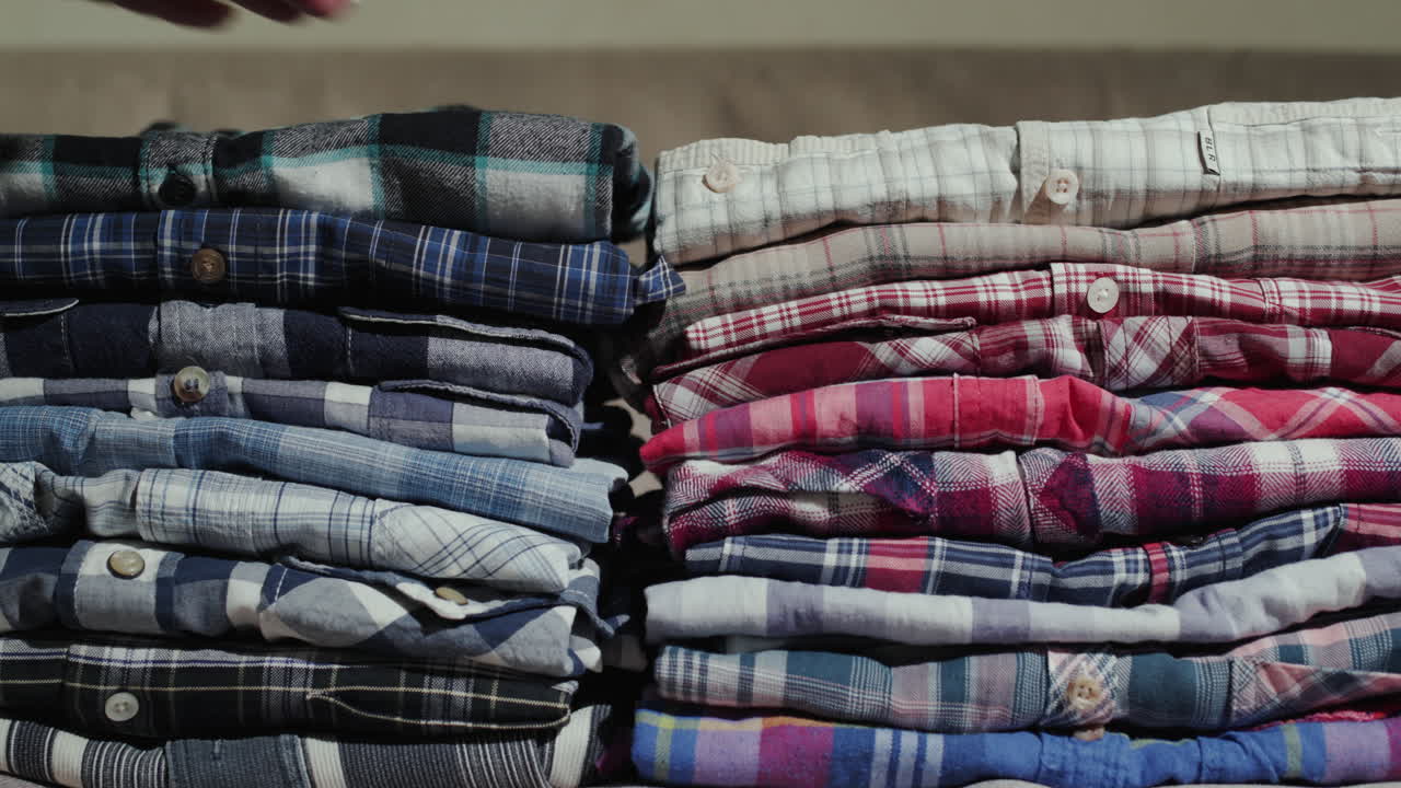 남자 셔츠 더미를 통해 여자의 손 정렬 1