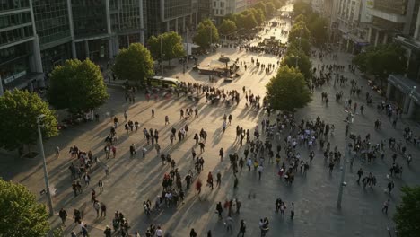 a vibrant crowd has come together in the city square, basking in the beautiful golden hour of the lively urban landscape