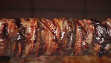 Close-up-shot-of-traditional-kokoretsi-spinning-on-spit-over-charcoal-traditional-easter-preparation-Pan-movement