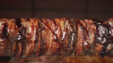 toma de cerca de kokoretsi tradicional girando en el escupido sobre el carbón de leña movimiento de sartén de preparación tradicional de pascua
