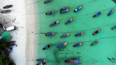 Top-view-of-a-beach-with-many-boats-anchored-and-people-walking