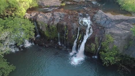 drone footage rising and pointing towards a small waterfall