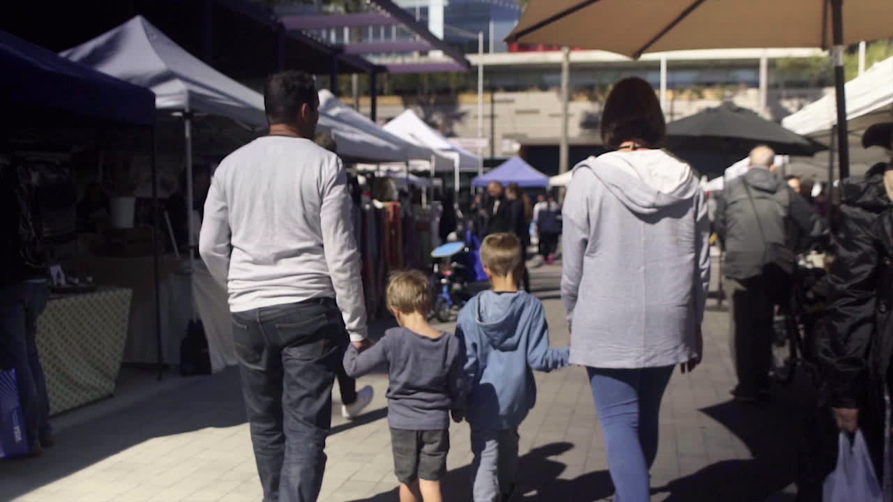 A family walks through a bustling outdoor market