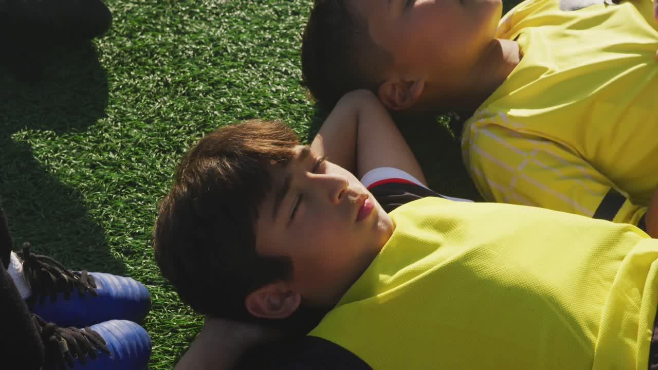 niños de fútbol descansando en un día soleado