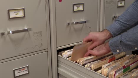 office working filing a folder in a file cabinet