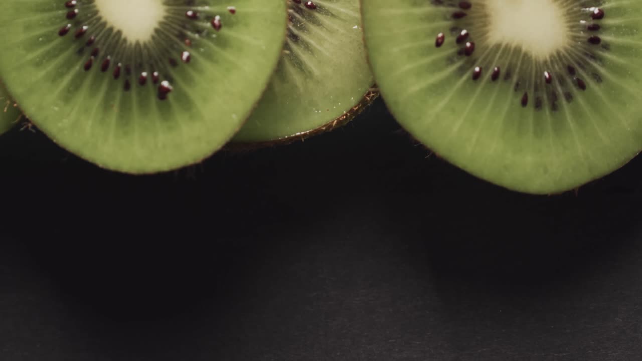 micro vídeo de close-up de fatias de kiwi com espaço de cópia em fundo preto