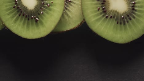 micro vídeo de primer plano de rebanadas de fruta de kiwi con espacio de copia en fondo negro
