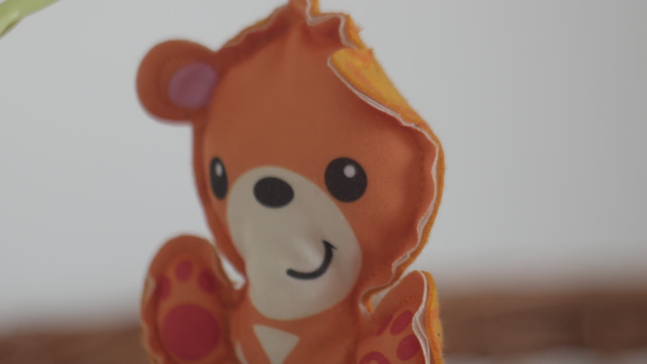 lindo osito de peluche colgado en el móvil de la cuna dentro de la habitación de la guardería