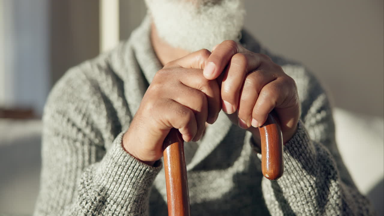 Closeup, senior and hands of man with cane