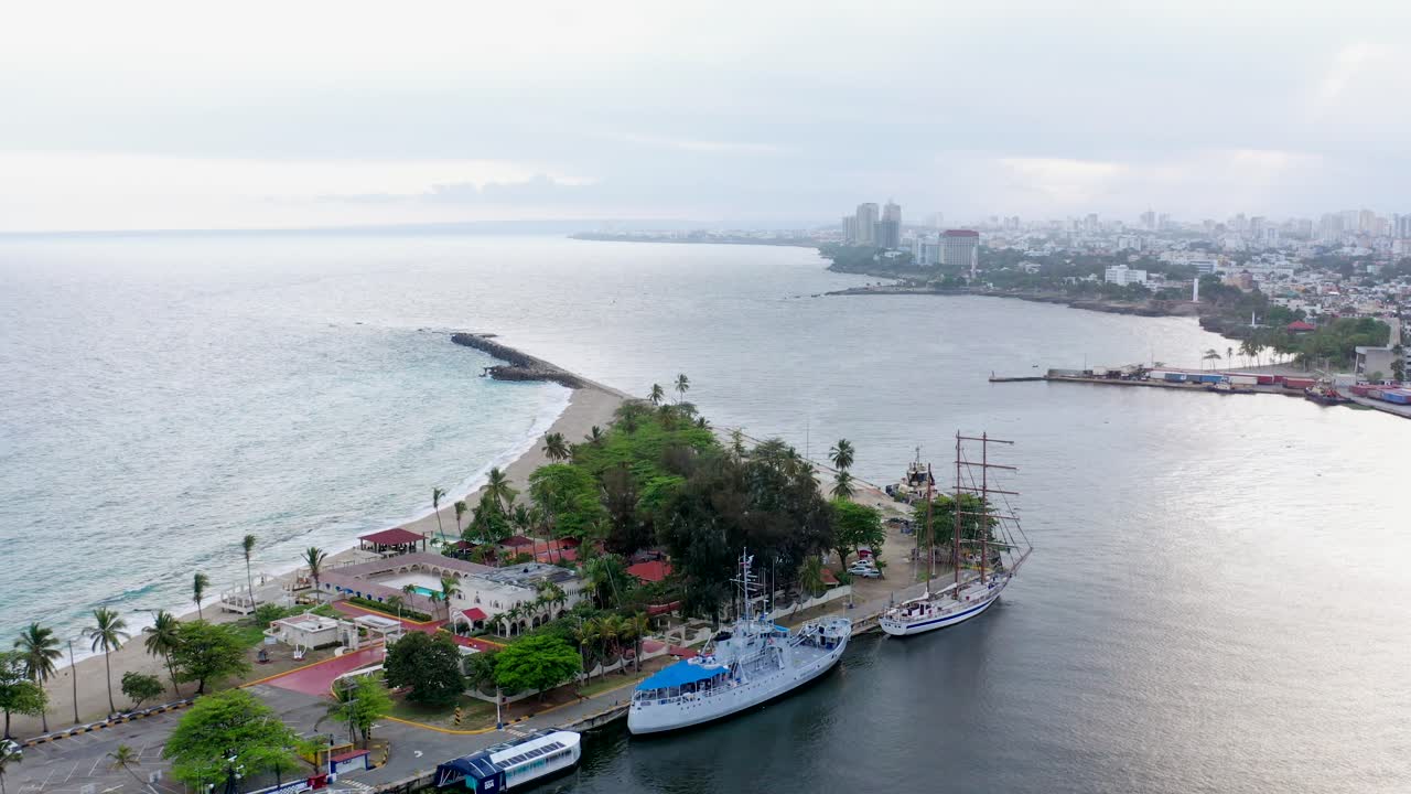 Veduta aerea del porto di Santo Domingo e della bellissima Punta Torrecilla con velieri attraccati al porto sull'acqua dell'oceano, Repubblica Dominicana, ripresa aerea circolare con drone