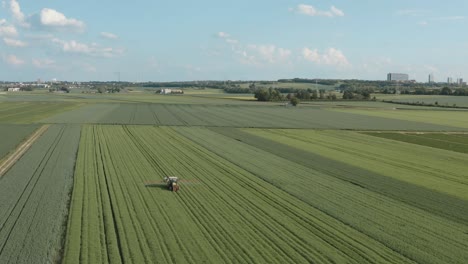aerial view of a tractor spraying crops in a green agricultural field