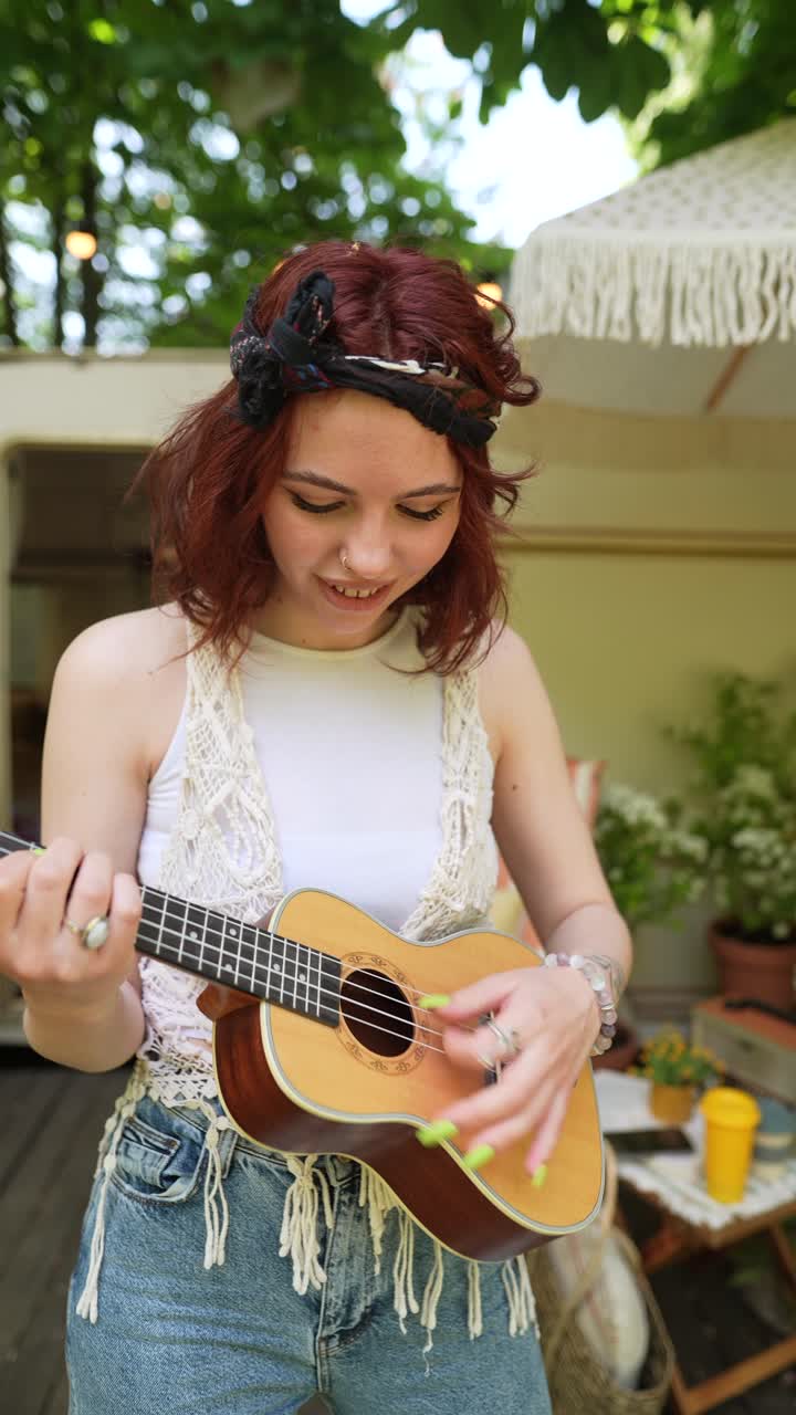mujer joven tocando el ukulele al aire libre