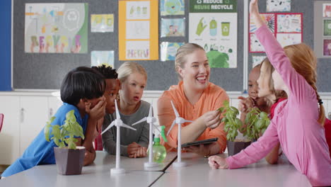 in school, female teacher using tablet teaching group of children about renewable energy