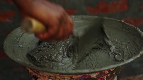 close up of male labor hand mixing cement preparing for building construction site