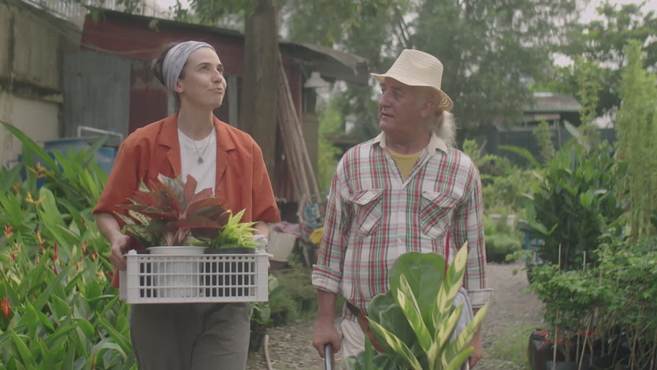 Plant Nursery Workers Walking in Garden and Speaking