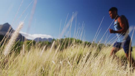 Hombre-Afroamericano-Corriendo-A-Campo-Traviesa-En-El-Campo-En-Una-Montaña