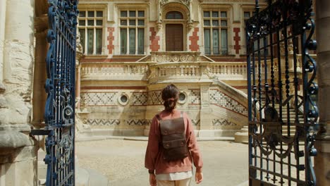 woman at the entrance of a historic european palace