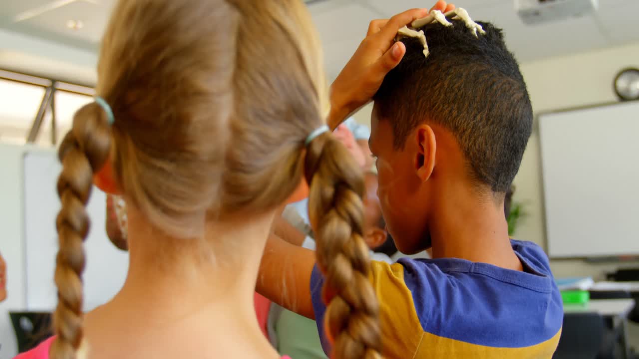 maestro caucásico que fija un modelo de esqueleto humano en el aula de la escuela 4k