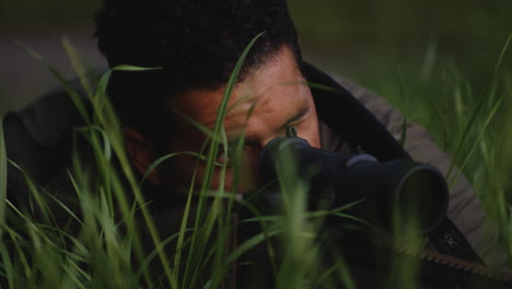 Tödliche-Präzision---Heimlicher-Scharfschütze-Zielt-Auf-Sein-Ziel,-Während-Er-Sich-Im-Gras-Versteckt