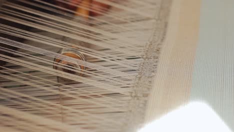 Cotton-yarn-fabric-pattern.-Closeup-woman-working-with-spinning-machine