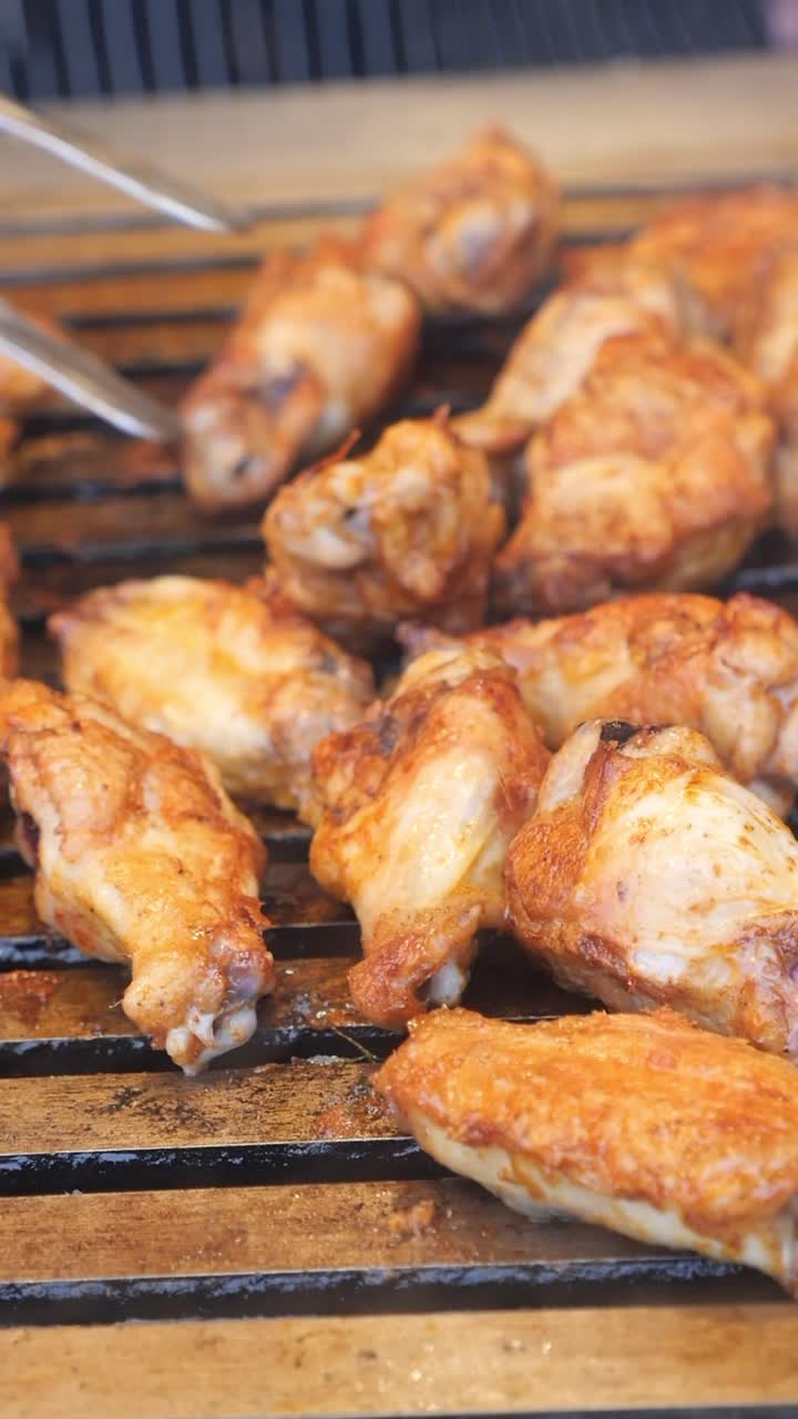 Ali di pollo che si dorano su una griglia calda