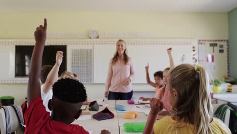 group of kids raising their hands in the class