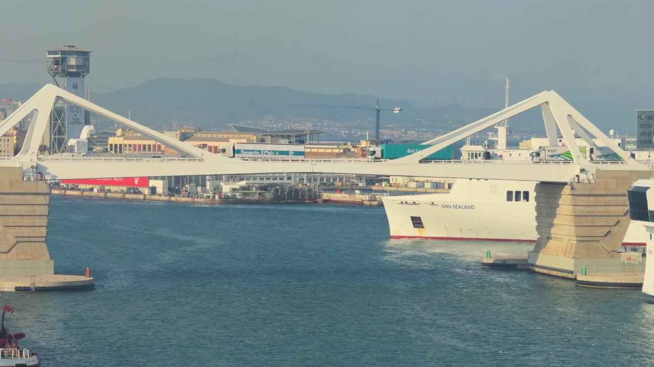 Famous bridge in the port of Barcelona with trucks, crossing and boats below