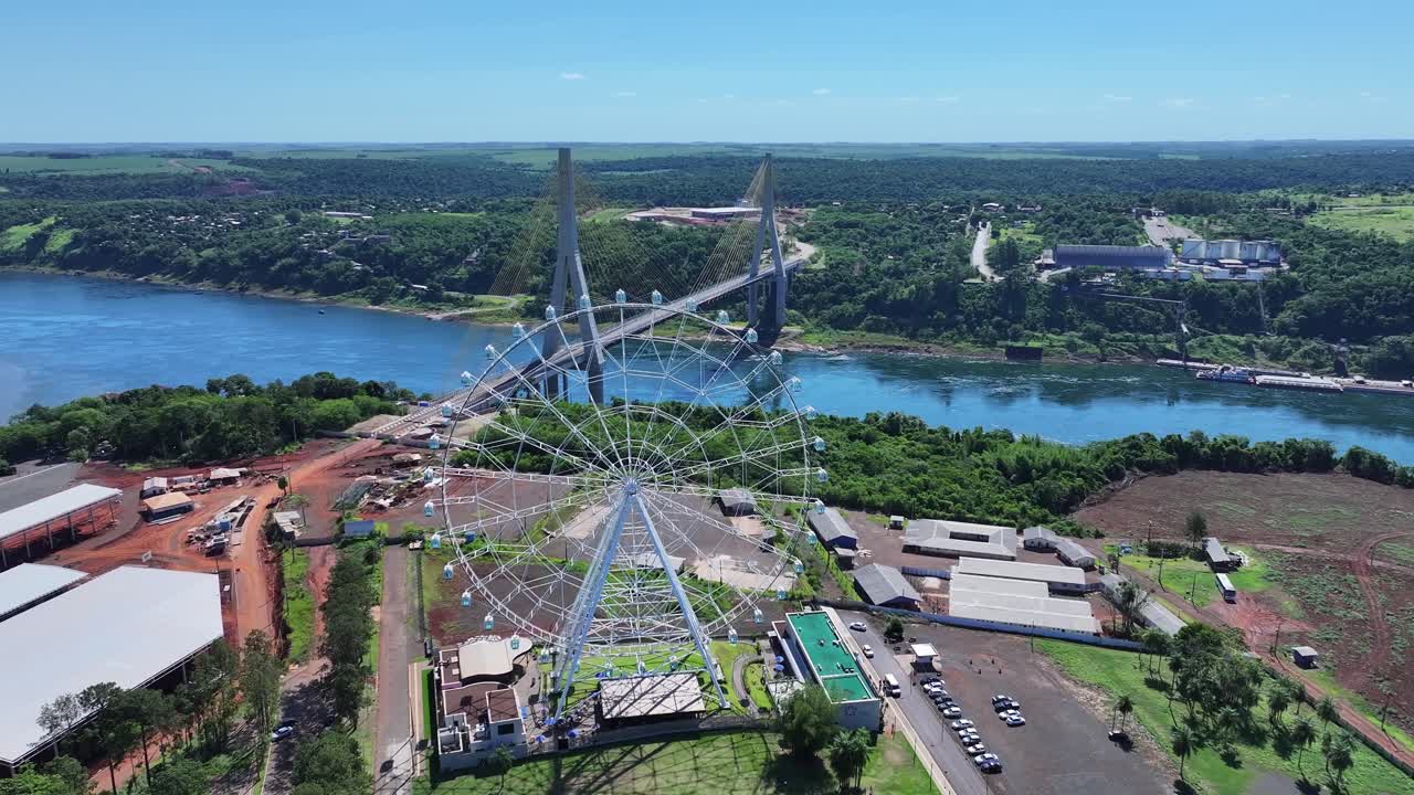 Drone view of Ferris wheel with individual cabins and 88 meters high, on the right Integration Bridge Brazil and Paraguay