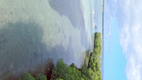 drone flying over tropical sea along la matica island, playa boca chica beach in dominican republic