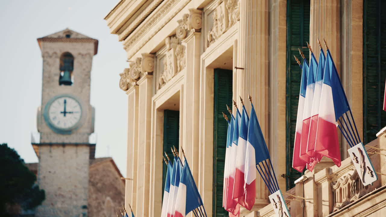 Campo lungo di un edificio storico decorato con bandiere tricolori francesi in una giornata limpida