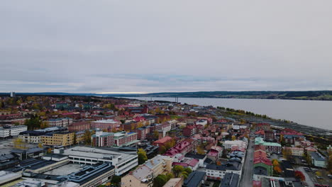 drone flying above urban landscape of ostersund in jamtland, sweden with storsjon lake in background - aerial