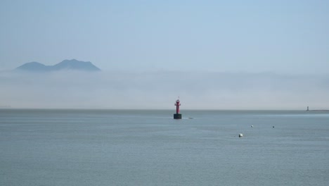 Rote-Boje-Im-Gelben-Meer,-Berg-Bedeckt-Mit-Dichtem-Weißem-Dunst-In-Der-Nähe-Der-Insel-Ganghwado,-Südkorea