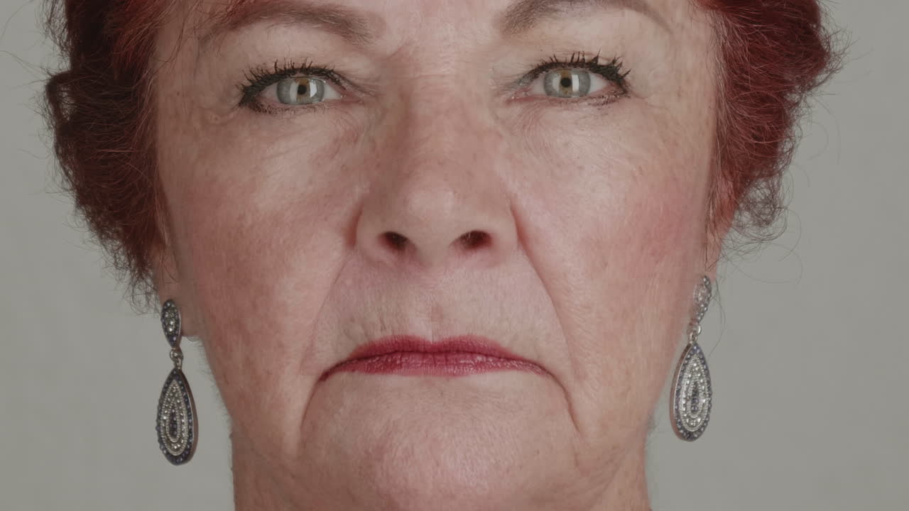 High-quality 4K footage of a confident senior woman (60s-70s) with styled hair and jewelry, friendly smile. Excellent for mature beauty, retirement, and health advertising