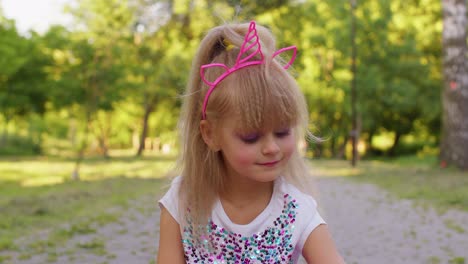 Happy-girl-playing,-spinning-with-pop-it-sensory-anti-stress-toy-in-park,-stress-anxiety-relief