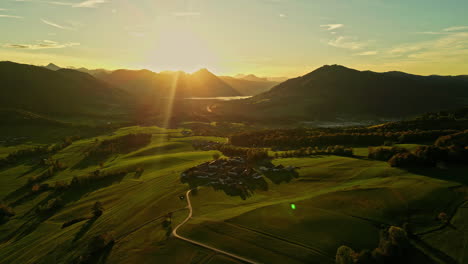 Golden-sun-rays-shoot-out-over-mountain-ridge-falling-on-rural-country-road