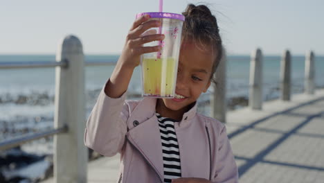 Porträt-Eines-Schönen-Kleinen-Mädchens-Mit-Saft,-Das-Glücklich-Lächelt-Und-Die-Warmen-Sommerferien-Am-Strand-Genießt