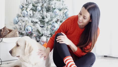 Lachende-Junge-Frau-Mit-Ihrem-Hund-Zu-Weihnachten