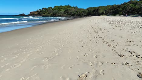 footprints on sandy beach with ocean waves