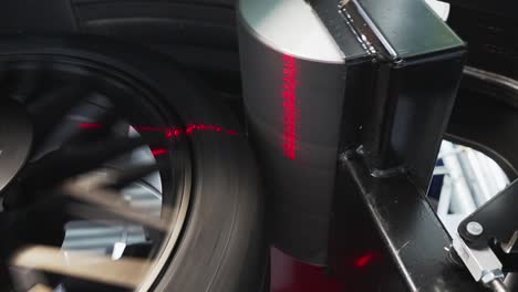 car wheel getting diagnosed by auto wheel balancer machine, closeup