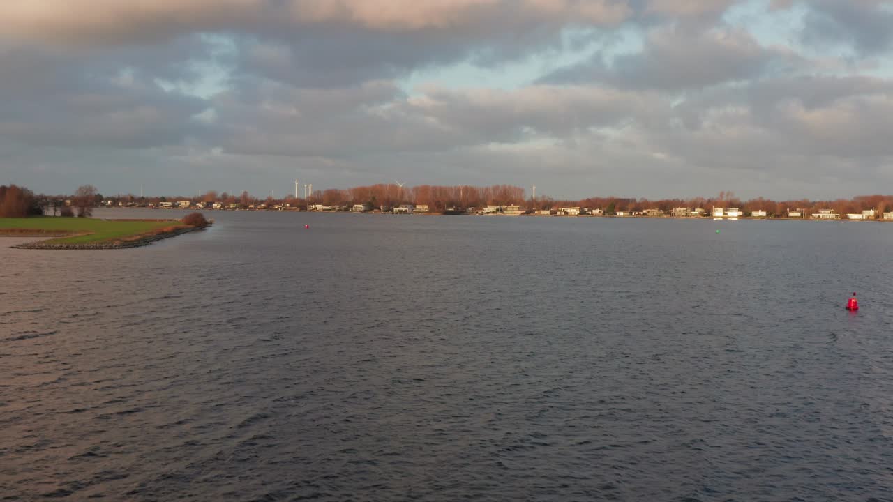 Vacation homes located at a lake during winter. Drone flying forward over water