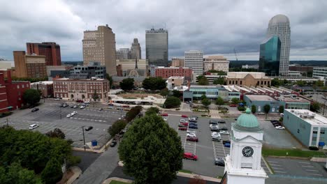 aerial push over moravian church steeple into winston salem skyline