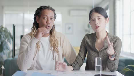 portrait of two diverse casual business colleagues making video call in office in slow motion