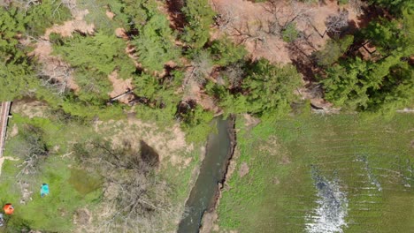 Aerial-reveal-of-a-park-with-exposed-rock-and-a-river-River-underneath