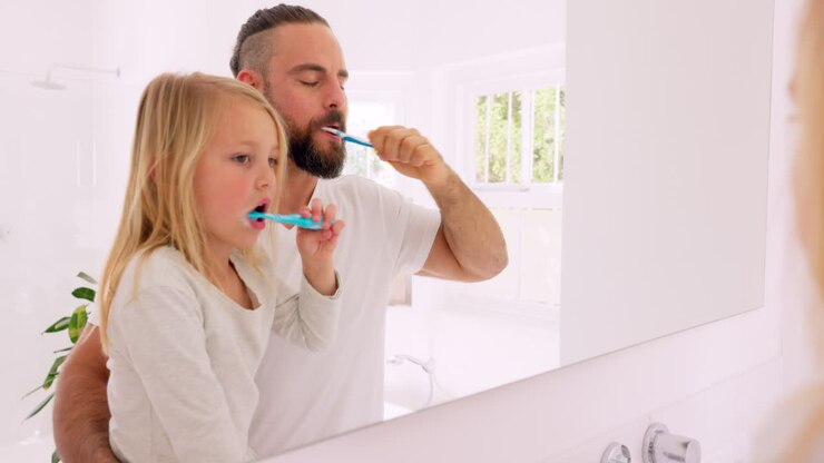 Father and Daughter Brushing Teeth