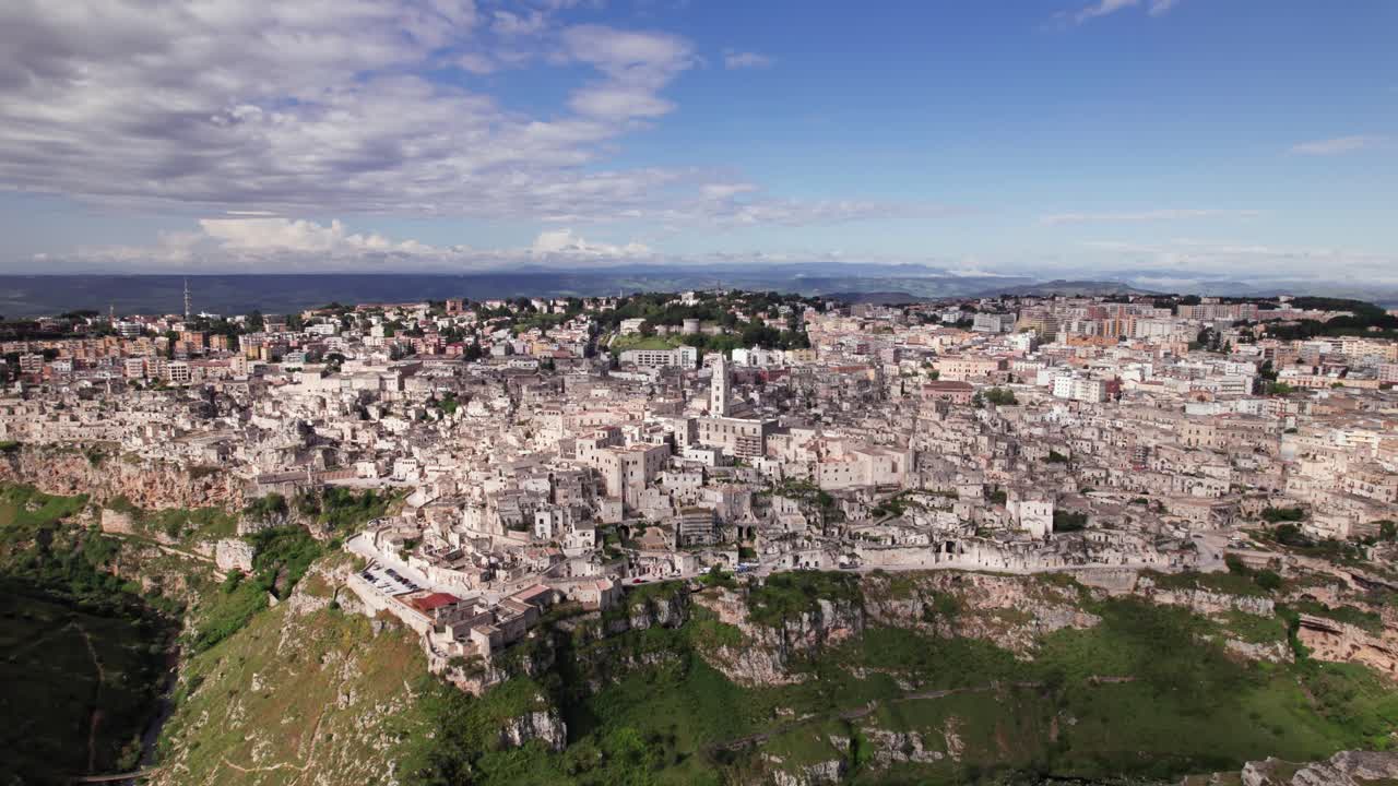 Aerial view of ancient old city Matera on edge top of rocky gorge on a sunny day
