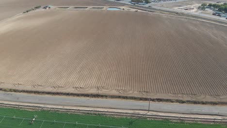 Aerial-of-a-perfectly-green-Southern-California-vegetable-field,-with-irrigation-equipment